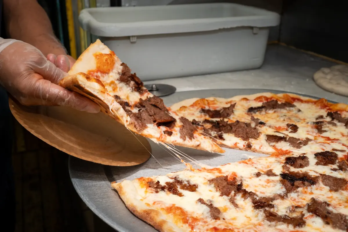 Cutting slices of gyro pizza