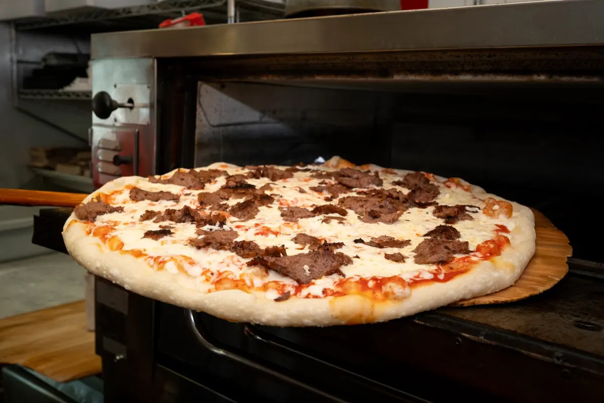 A gyro pizza coming out of the oven